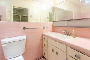 Full bath featuring vanity and tile walls