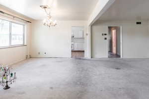 Unfurnished dining area with hanging lights and carpet
