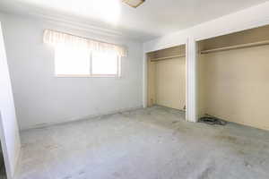 Unfurnished bedroom with multiple closets and carpet floors