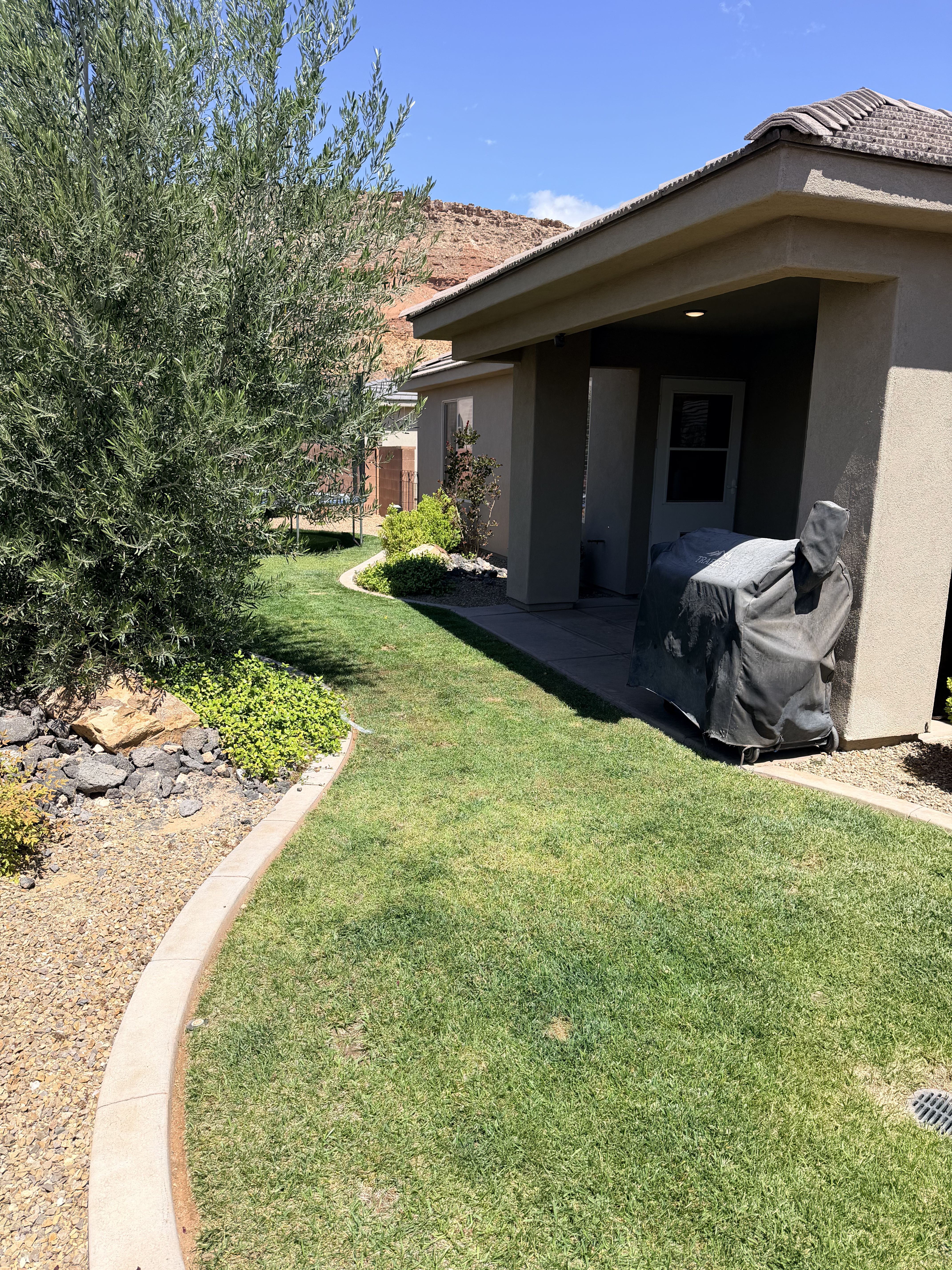 View of grassy yard featuring a patio area