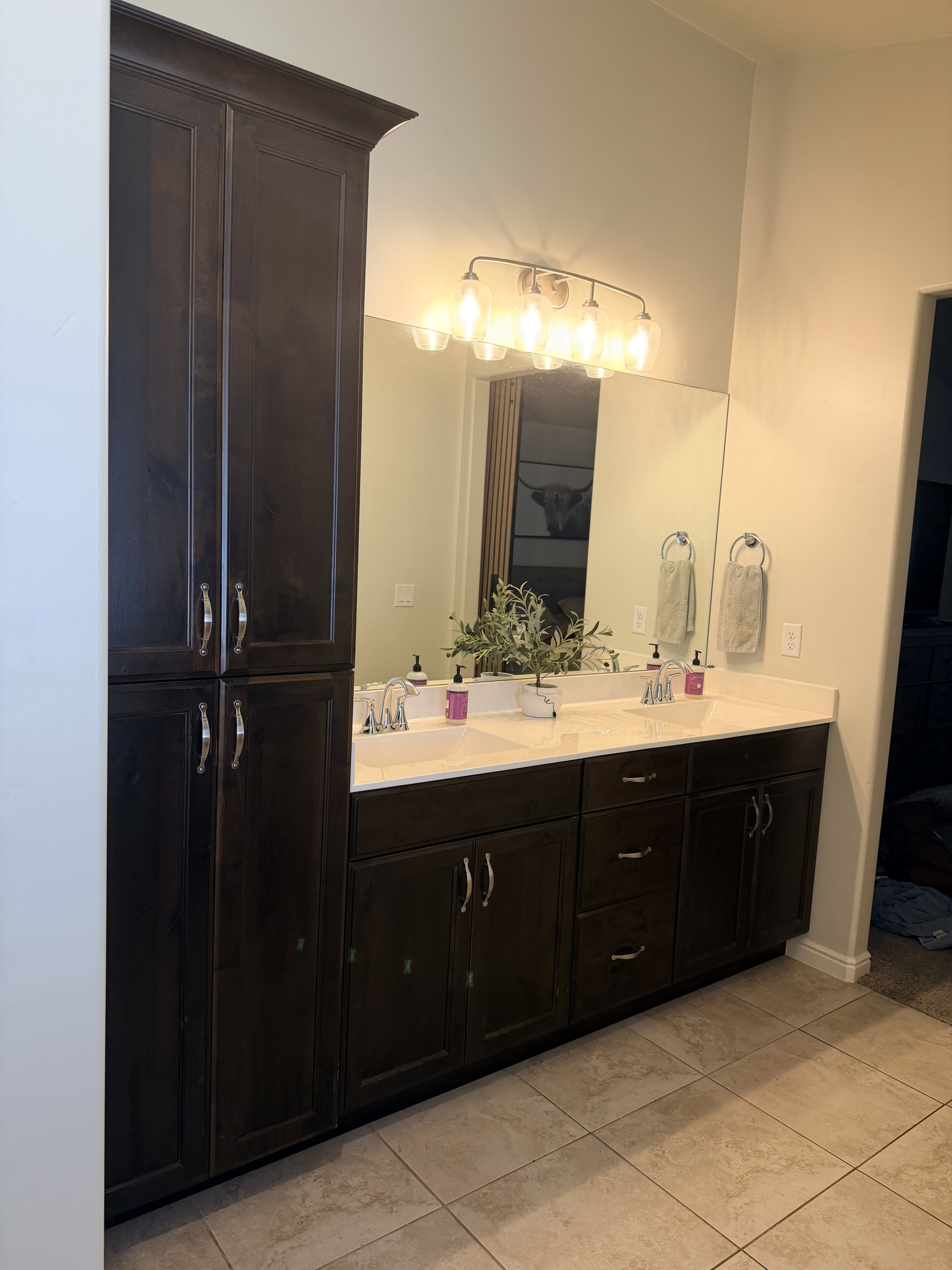 Ensuite bathroom with double vanity and light tile patterned flooring