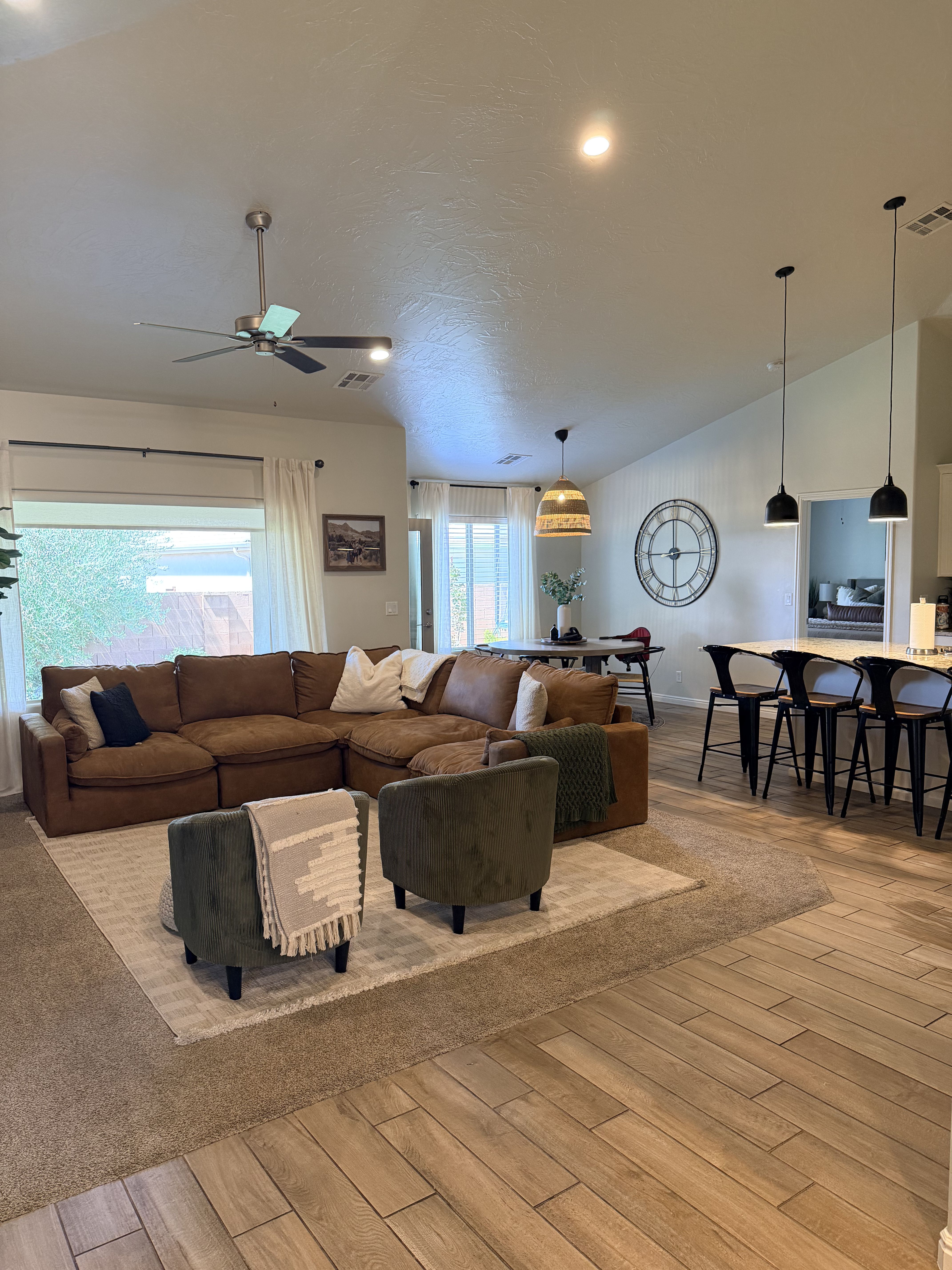 Living room with light wood finished floors, ceiling fan, lofted ceiling, and recessed lighting