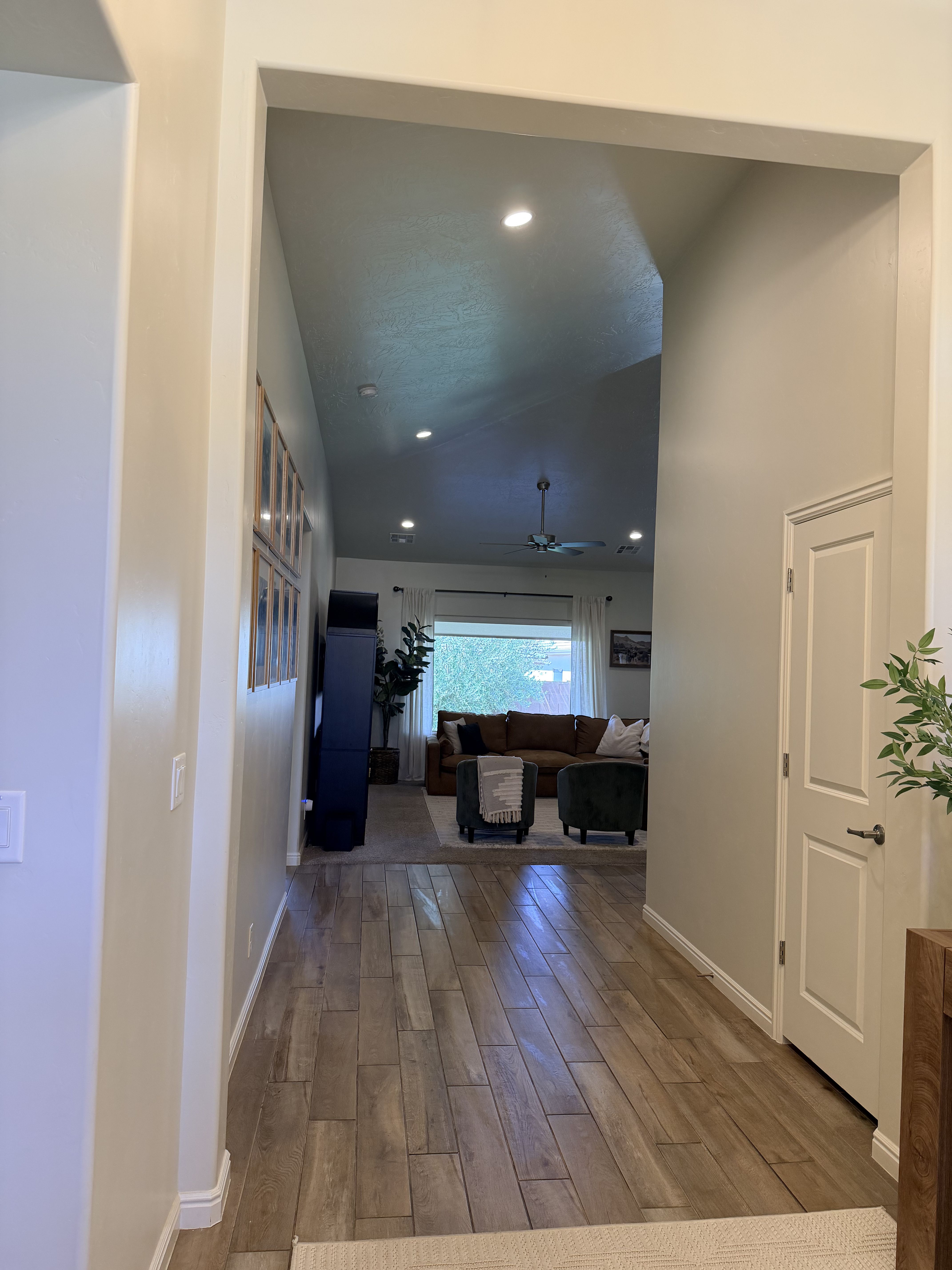 Hallway featuring wood tiled floors, vaulted ceiling, and recessed lighting
