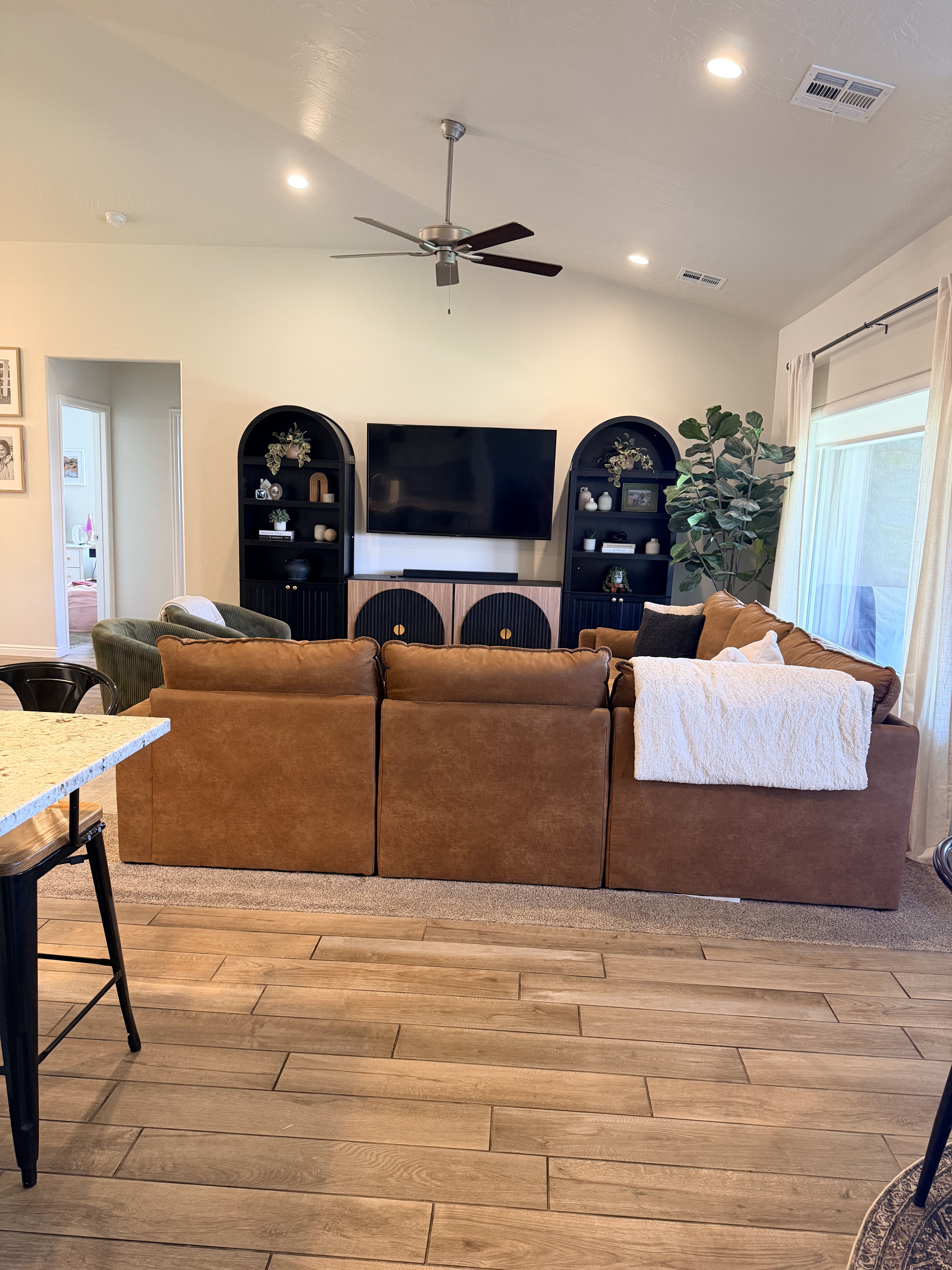 Living area featuring vaulted ceiling, light wood-type flooring, ceiling fan, and recessed lighting