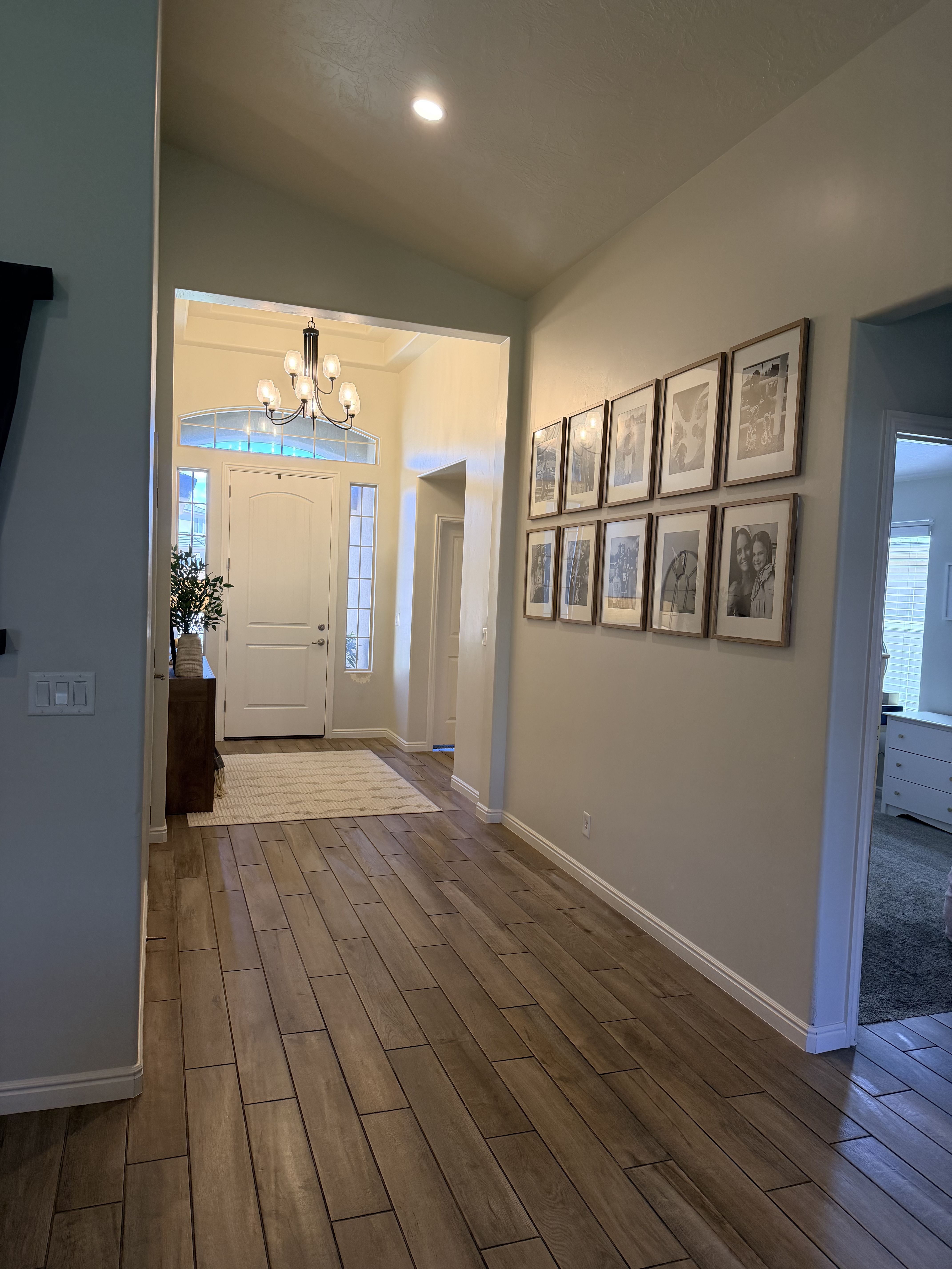 Entrance foyer featuring wood finish floors, vaulted ceiling, and a chandelier