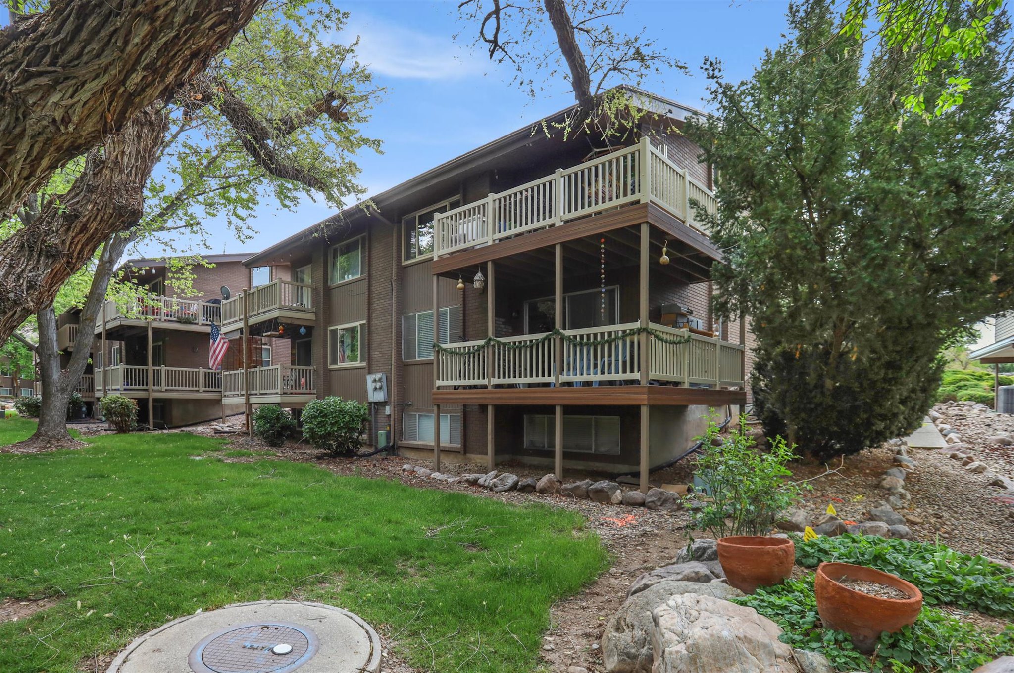 Rear view of property featuring a lawn and a balcony