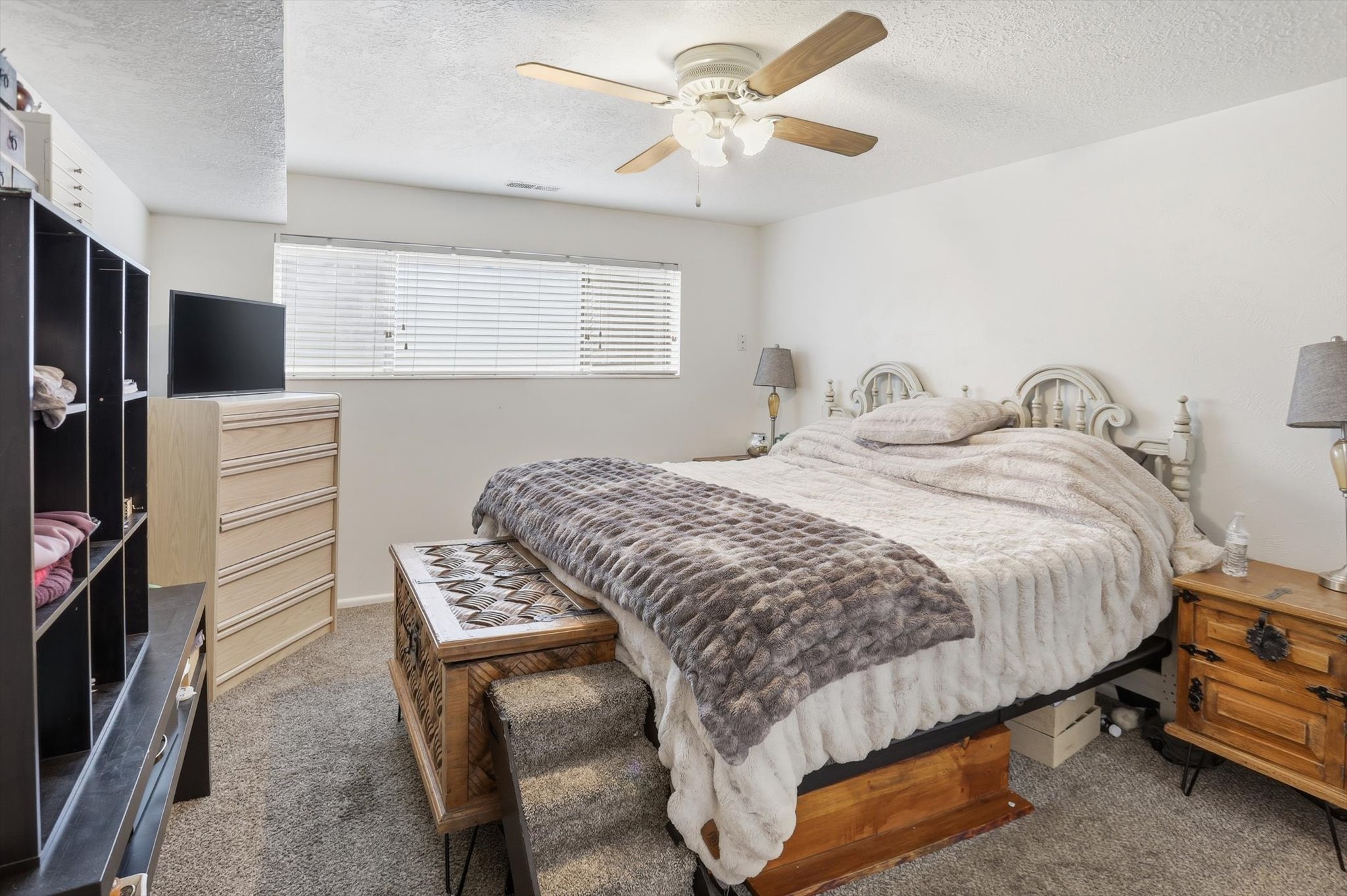 Bedroom featuring carpet flooring, ceiling fan, and a textured ceiling