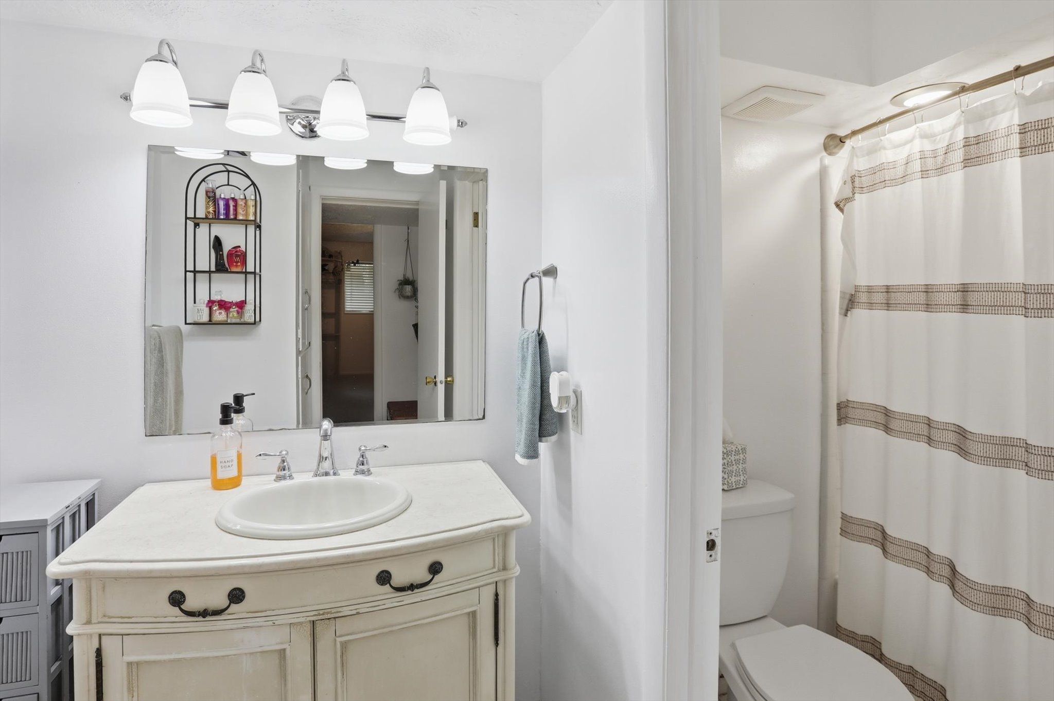 Full bath with curtained shower and vanity