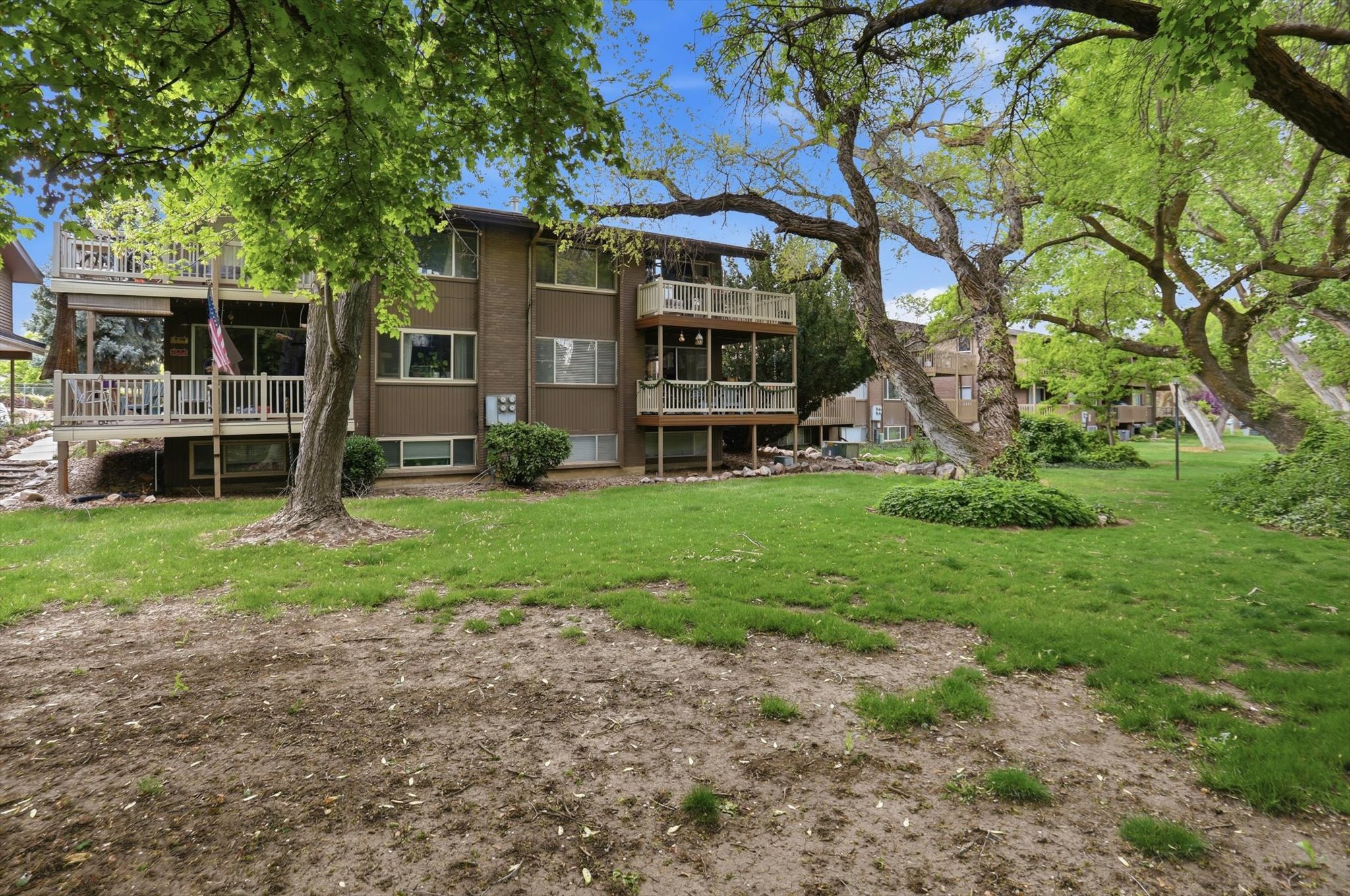 Back of property with a yard, stucco siding, and a balcony