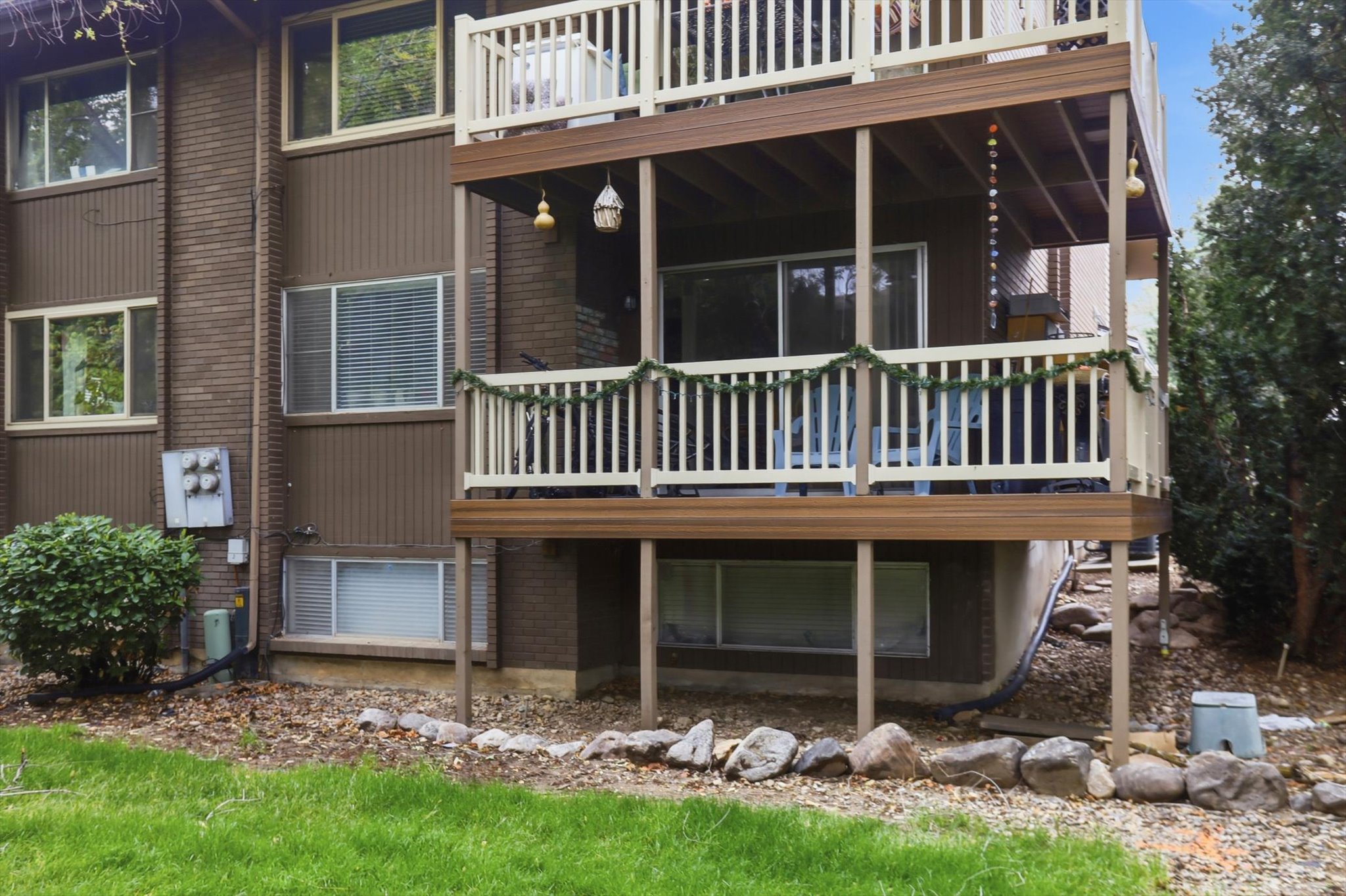 Back of property with a deck and brick siding