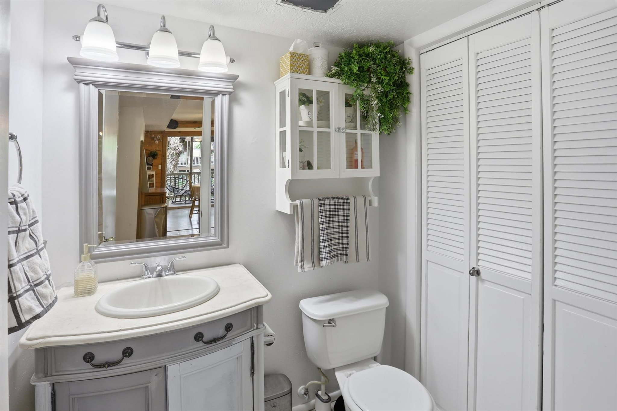 Bathroom with a closet, vanity, and a textured ceiling