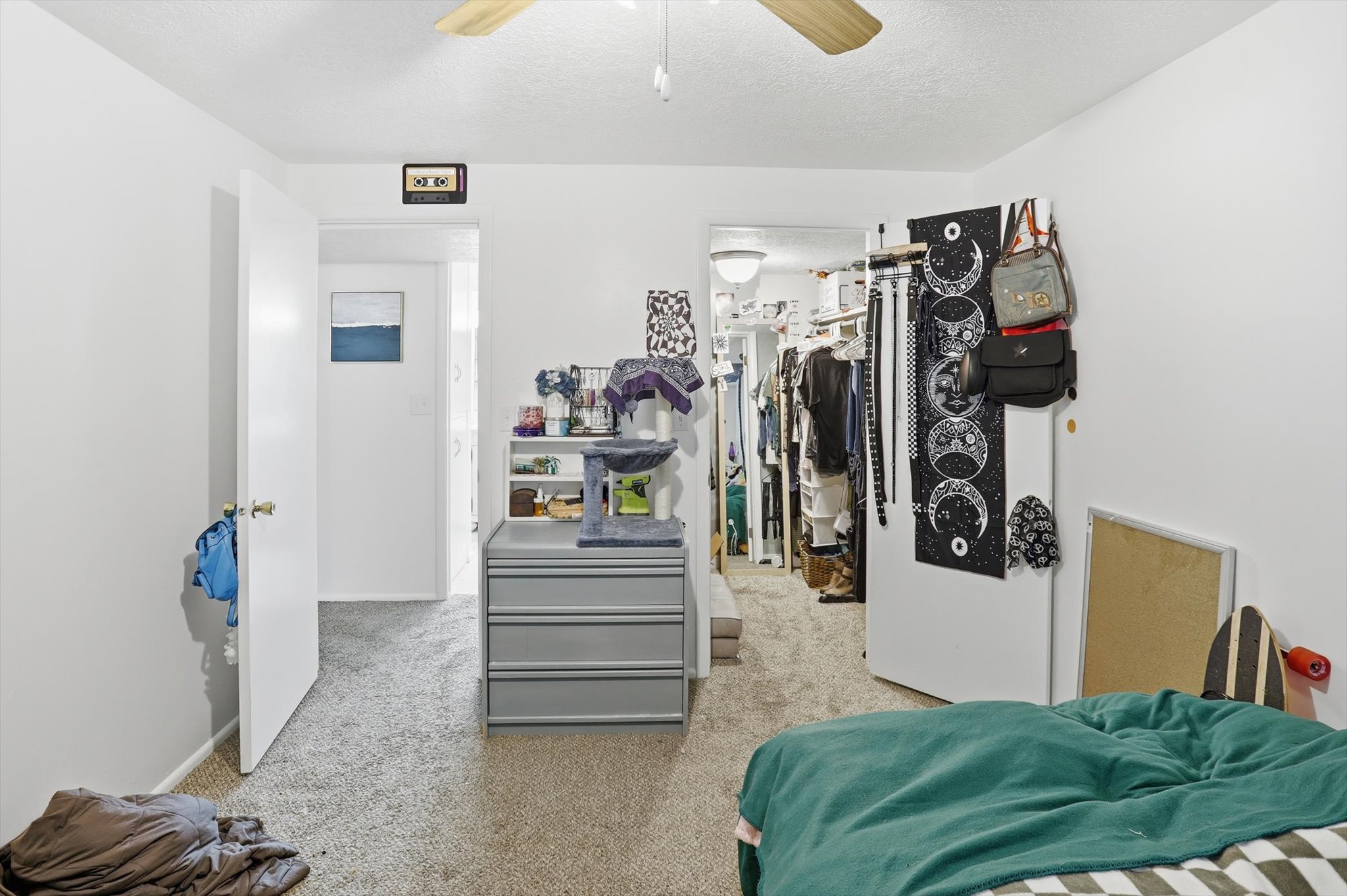 Misc room featuring ceiling fan, light carpet, and a textured ceiling