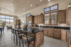 Kitchen with a center island, a breakfast bar area, recessed lighting, dark stone counters, and a mountain view