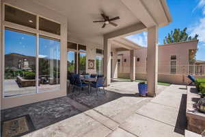 View of patio with outdoor dining area and a ceiling fan
