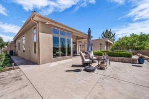 Rear view of house with stucco siding and a patio area