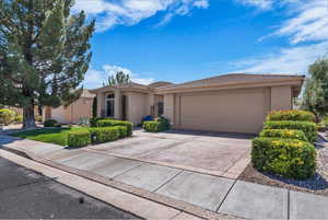 View of front facade with an attached garage, concrete driveway, stucco siding, and a tiled roof