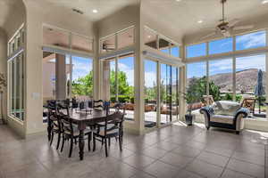 Sunroom with a high ceiling, tile patterned floors, and a mountain view
