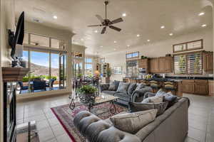 Living area with a ceiling fan, recessed lighting, a high ceiling, and light tile patterned floors