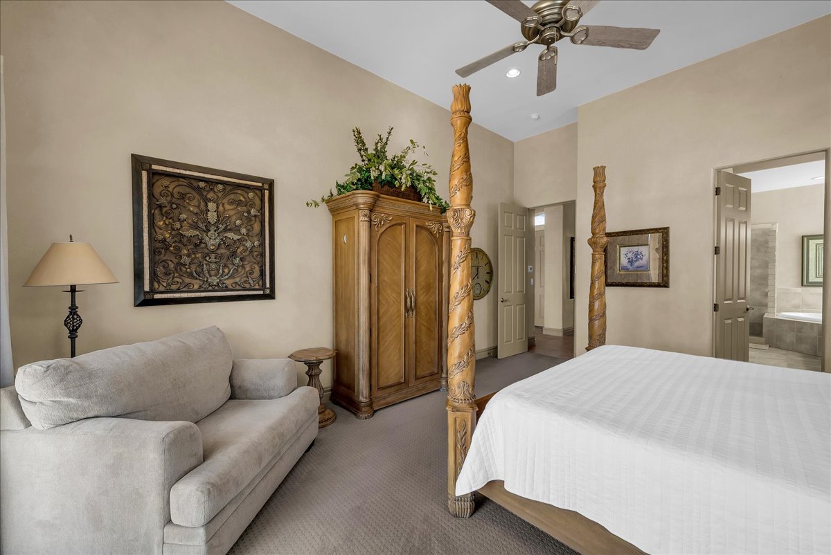 Carpeted bedroom with ceiling fan, ensuite bath, and recessed lighting