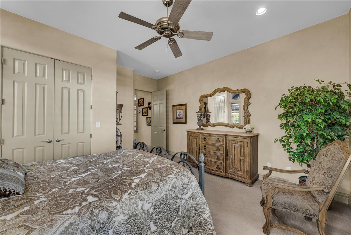Bedroom with light carpet, ceiling fan, a closet, and recessed lighting