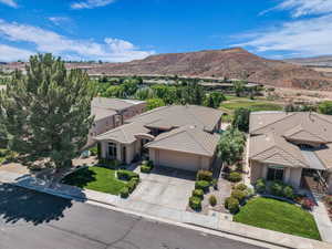 Aerial view of property and surrounding area featuring a mountainous background