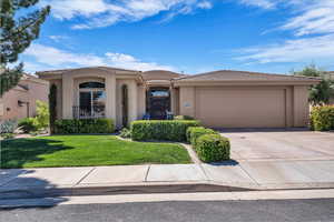 View of front facade featuring a tiled roof, concrete driveway, a garage, and stucco siding