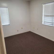Empty room with dark carpet and plenty of natural light