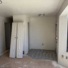 Unfurnished bedroom featuring a textured ceiling and light tile patterned floors