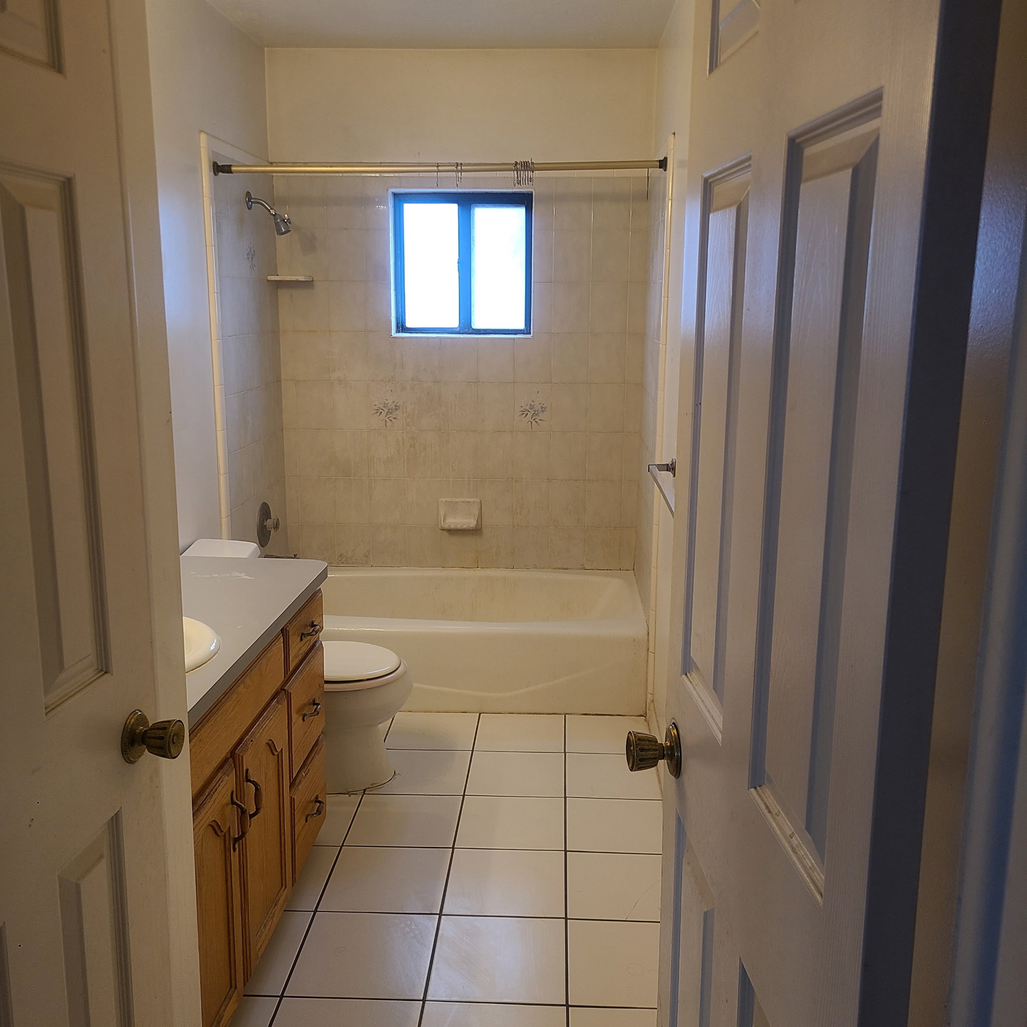 Full bath with vanity, light tile patterned floors, and bathtub / shower combination