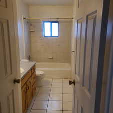 Full bath with vanity, light tile patterned floors, and bathtub / shower combination