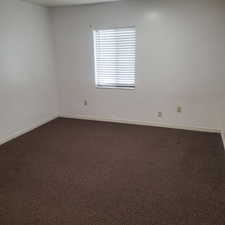 Unfurnished room with dark colored carpet and baseboards