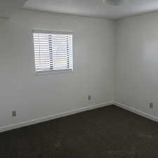 Empty room featuring dark carpet and a textured ceiling