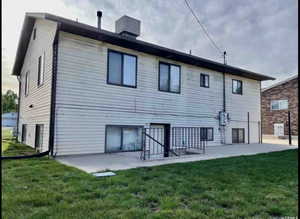 Rear view of property with a lawn and a patio area