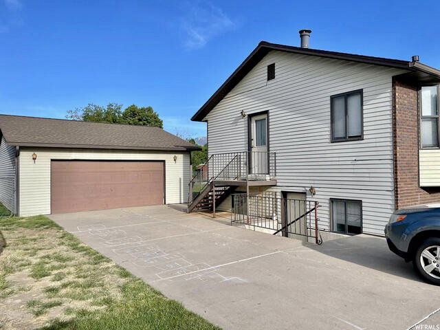 View of front of home with an outdoor structure and a garage