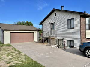 View of front of home with an outdoor structure and a garage