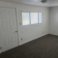 Spare room featuring dark colored carpet and a textured ceiling