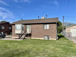 Back of house with brick siding, a chimney, and a mountain view
