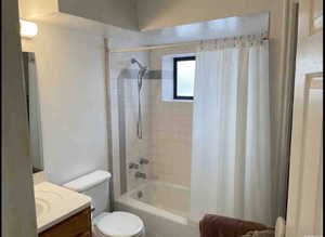 Bathroom featuring vanity and shower / bath combination with curtain
