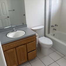 Bathroom featuring vanity, light tile patterned floors, and shower / washtub combination