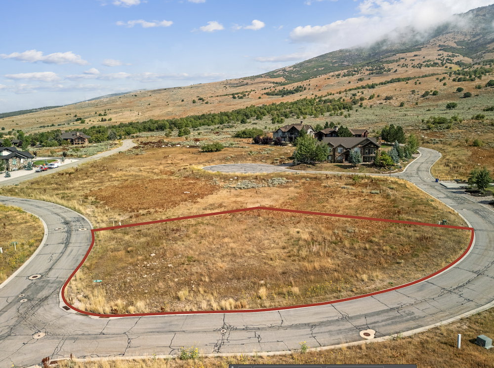 Expansive land parcel featuring natural terrain and a backdrop of mountains