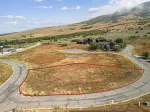 Expansive land parcel featuring natural terrain and a backdrop of mountains