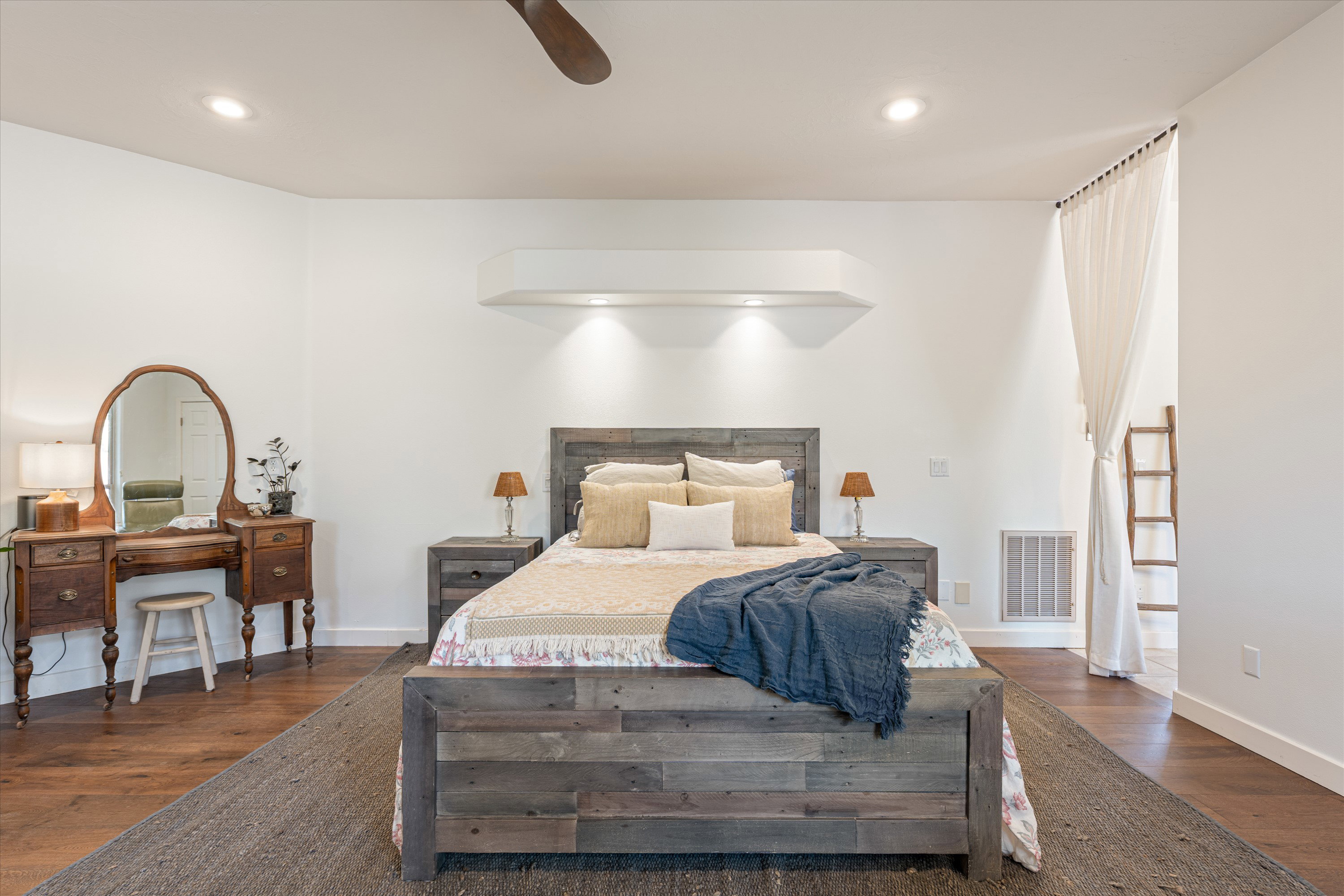 Recessed lighting illuminates a feature wall with an integrated shelf