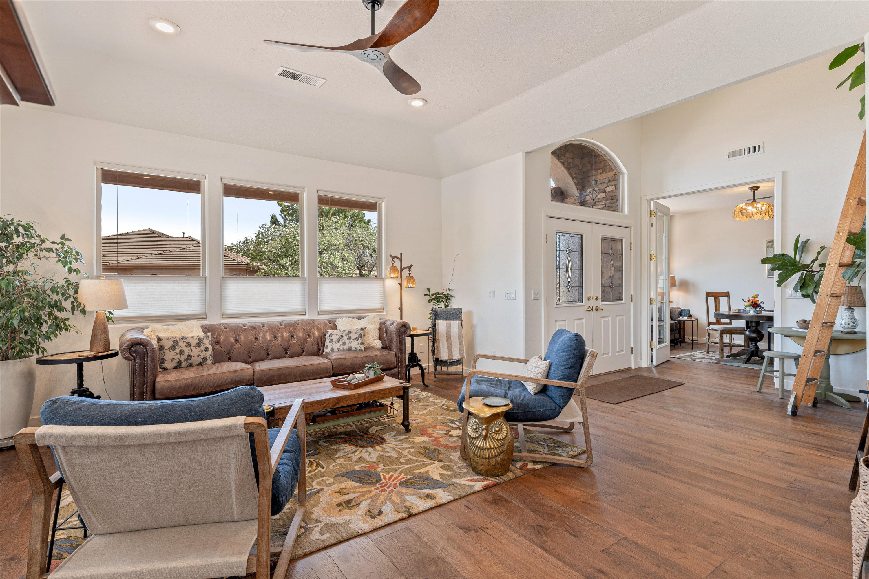 Living room with dark wood finished floors, ceiling fan, recessed lighting, and vaulted ceiling