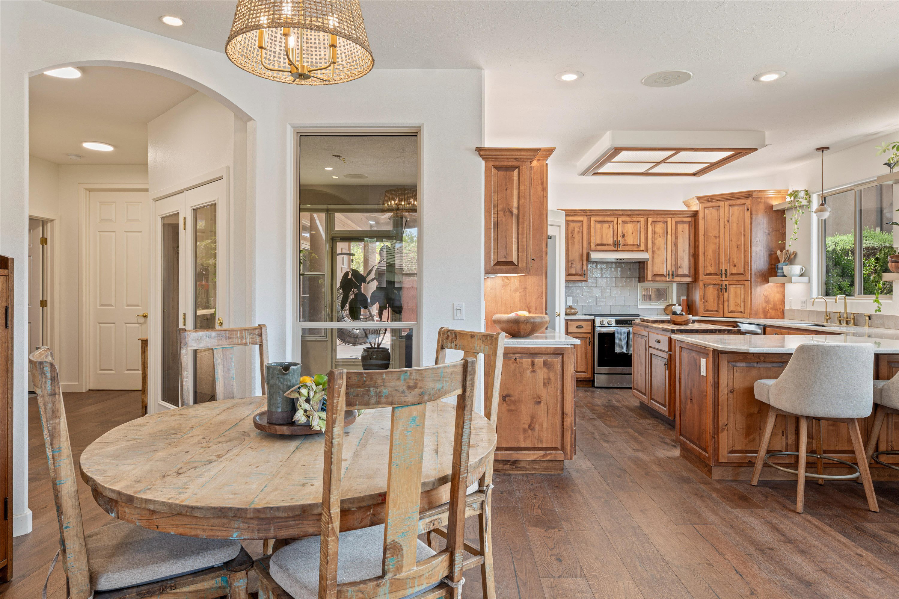 Dining area featuring arched walkways, dark wood-type flooring, and suspended lighting