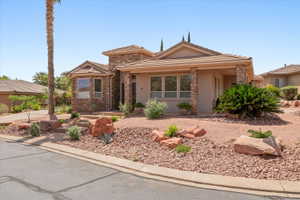 View of front of property with stone siding, stucco siding, a porch, and a tiled roof