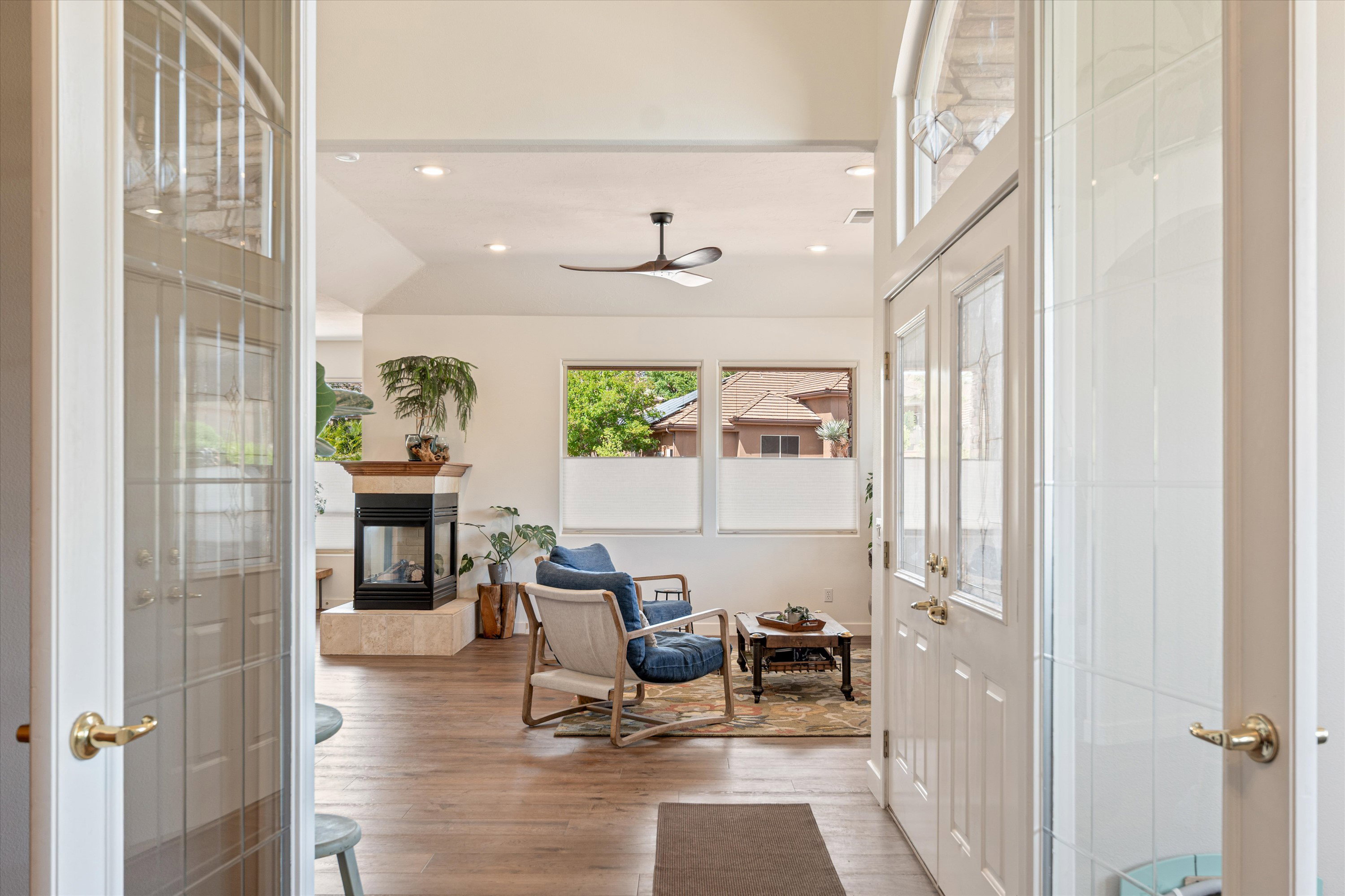 Living area featuring recessed lighting, a multi sided fireplace, light wood-style floors, a ceiling fan, and vaulted ceiling