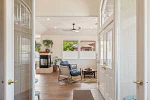 Living area featuring recessed lighting, a multi sided fireplace, light wood-style floors, a ceiling fan, and vaulted ceiling