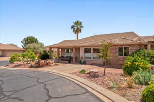 Single story home featuring a tile roof, stone siding, a porch, and stucco siding