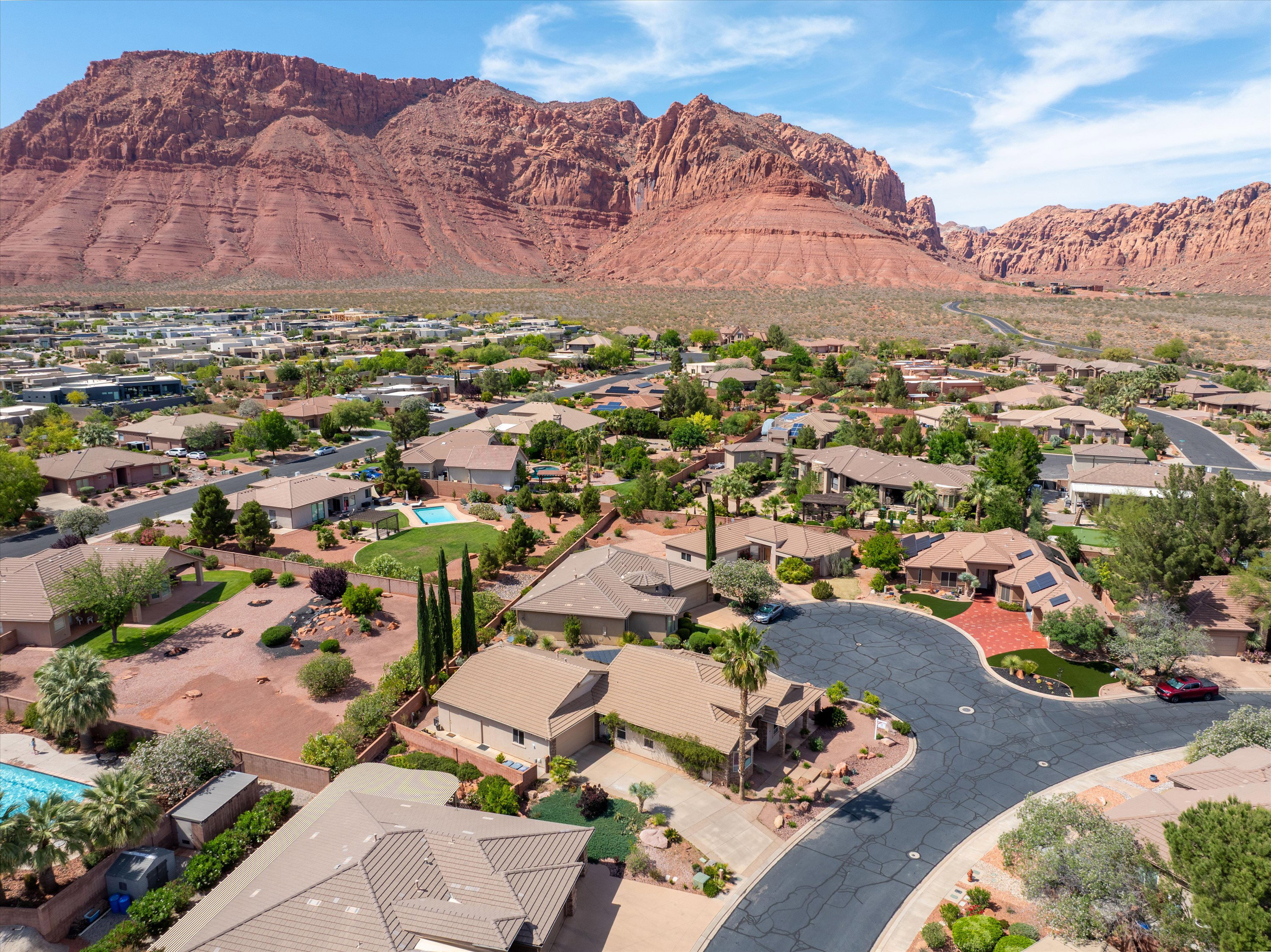 Aerial perspective of suburban area with a mountainous background and a pool area
