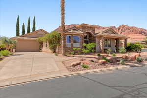 View of front of property featuring stone siding, driveway, and a garage